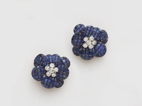 
    
            
                    A pair of French 18k yellow gold diamond and mysterious-set sapphire "Pavot" earclips.
                
        
