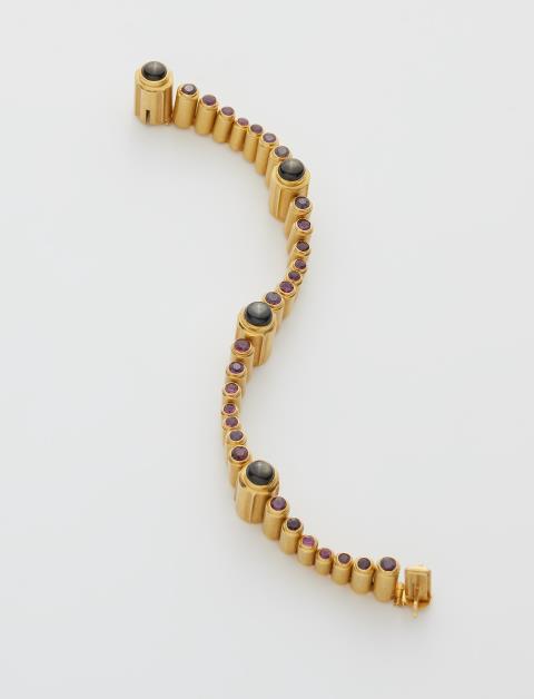
    
            
                    A German 18k gold ruby and black star sapphire hinged line bracelet.
                
        
